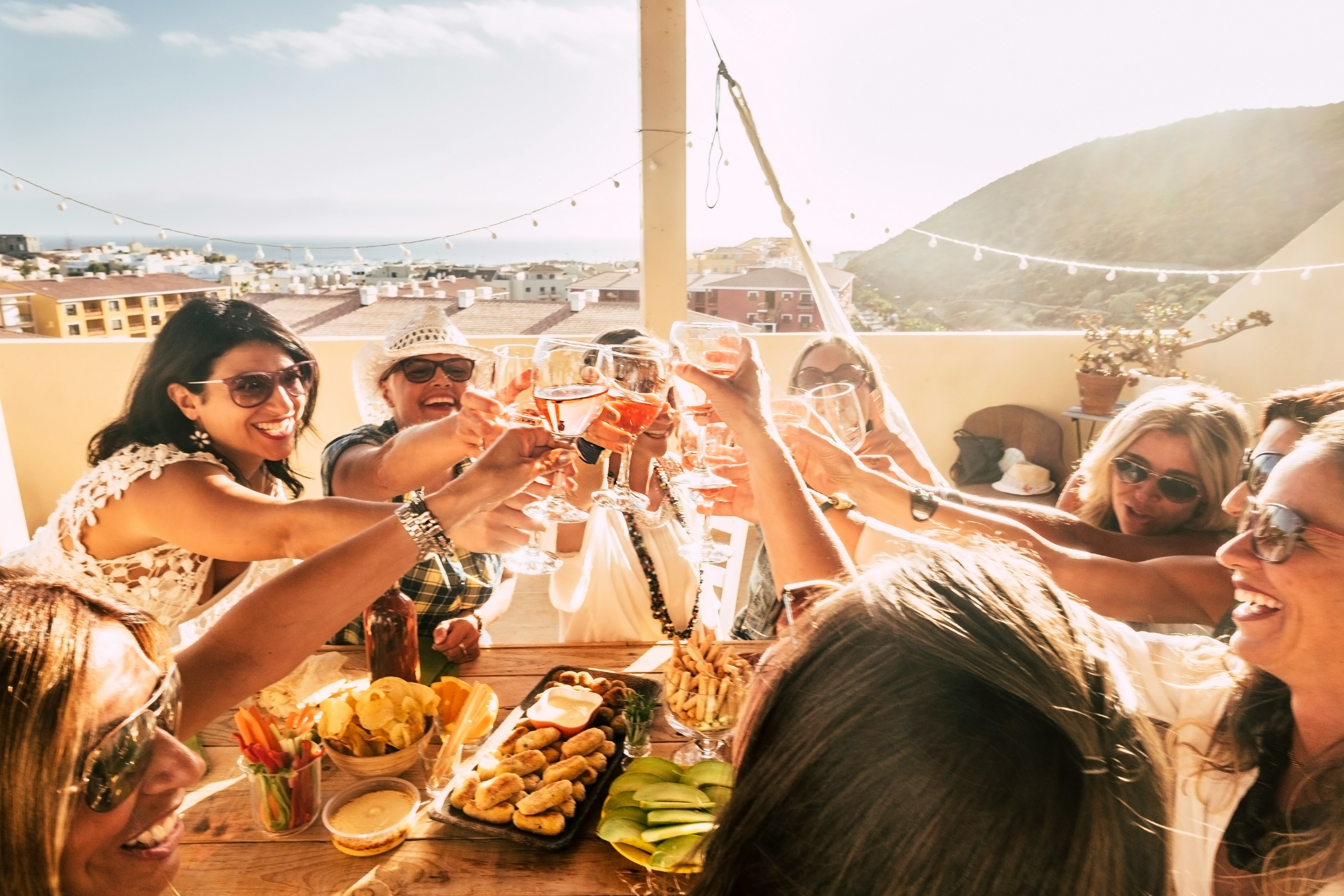 Friends sharing wine and small plates on a sunny terrace