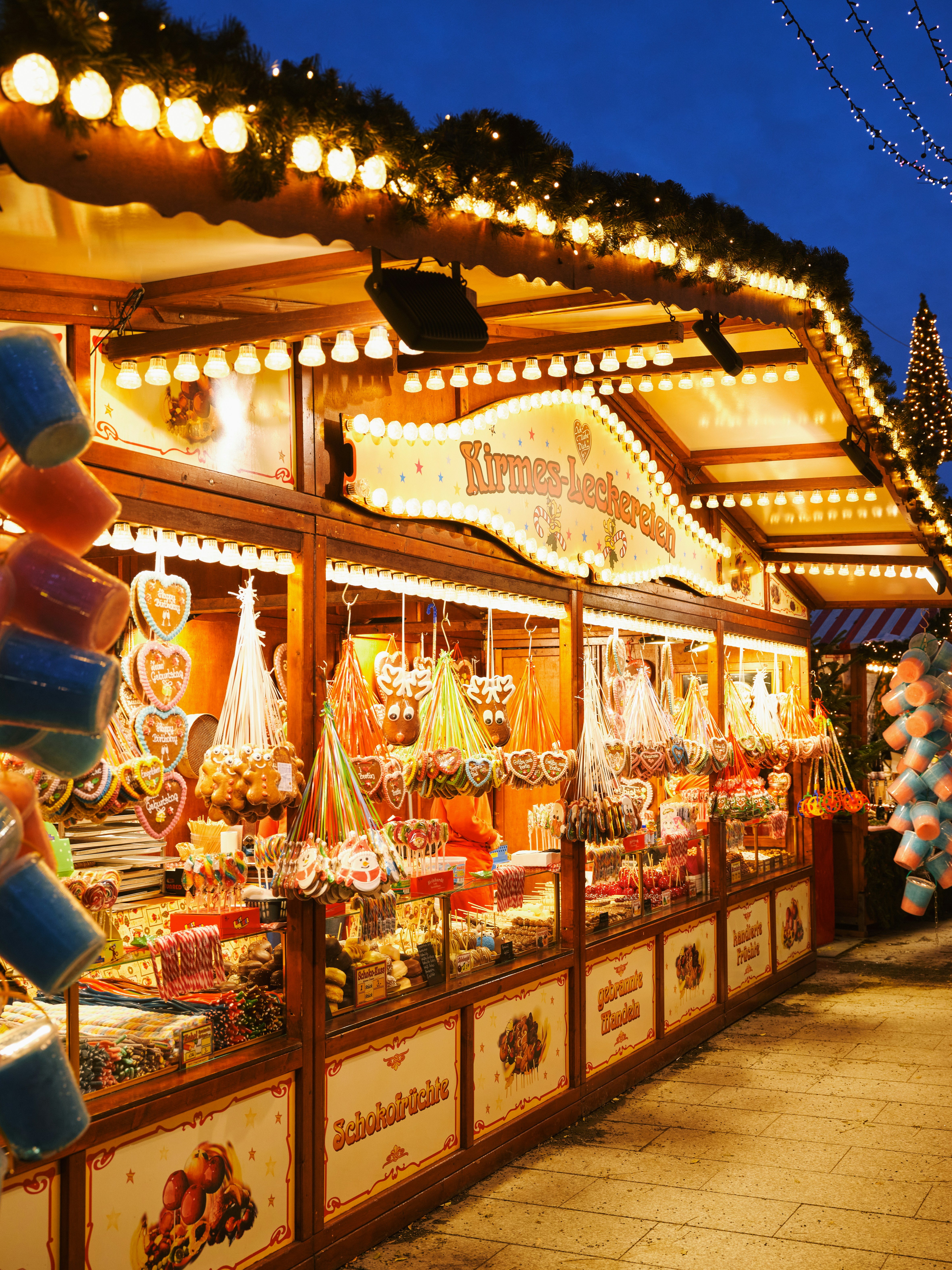 A glowing Christmas market stall hung with gingerbread hearts