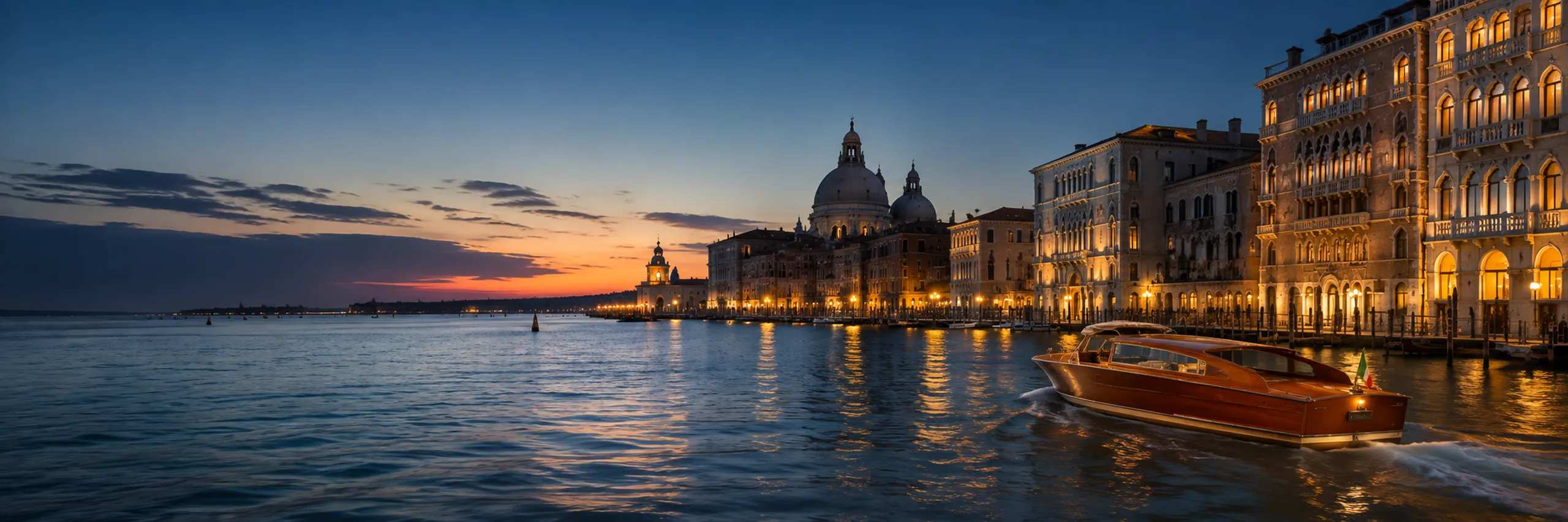 Venice Grand Canal at dusk with a classic wooden water taxi, illuminated historic palazzos, and reflections across the water beneath a deep blue evening sky.