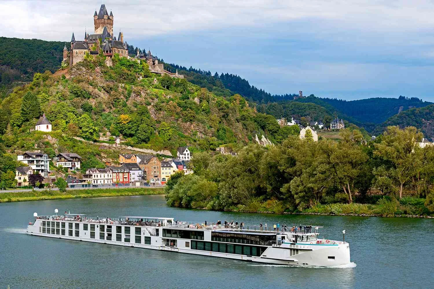 Luxury river cruise ship sailing through a European waterway at golden hour