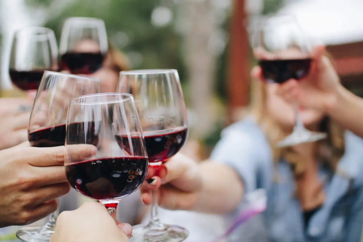 Friends raising glasses of red wine together